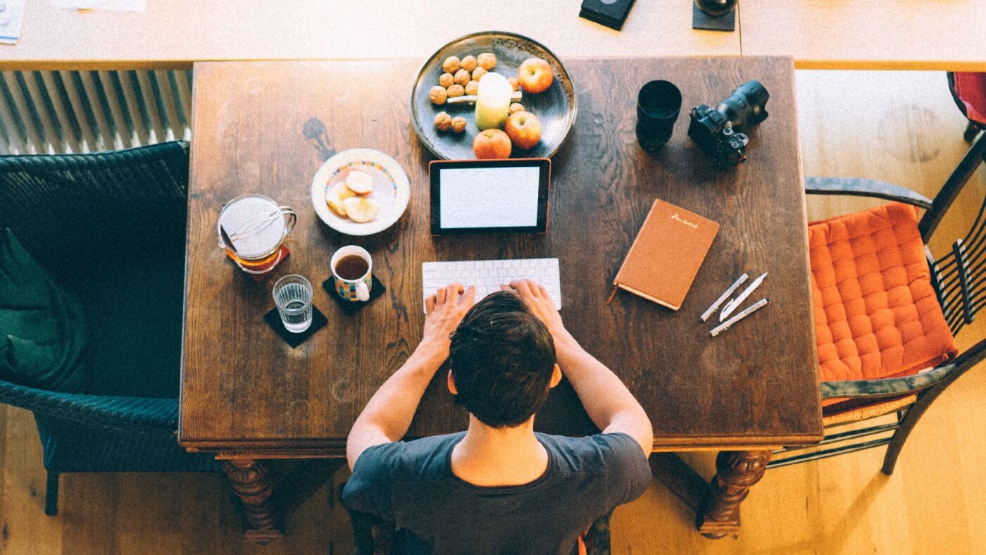 ragazzo lavora in smart working sul tavolo della cucina